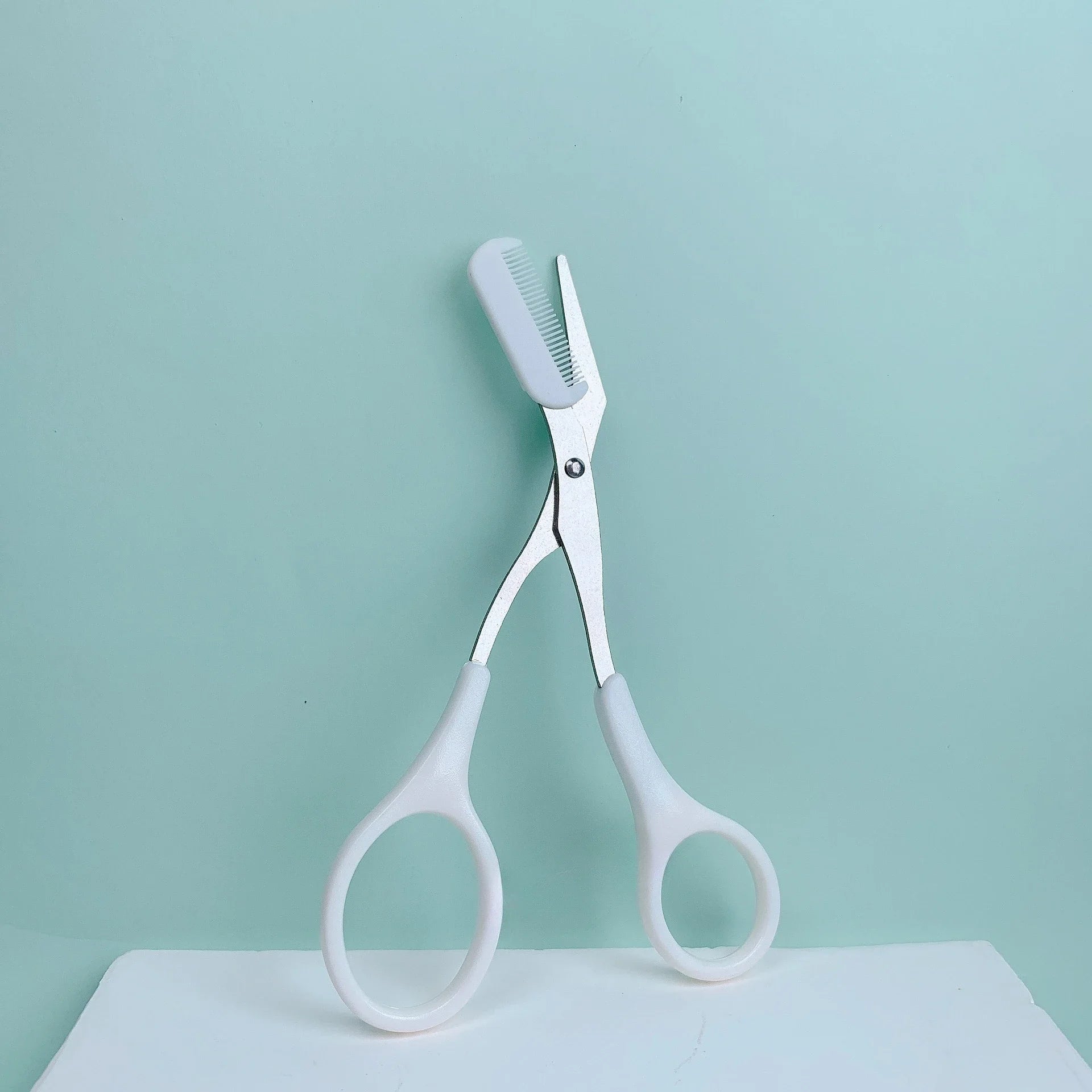 Pink eyebrow trimming scissors with built-in comb - stainless steel, precise grooming tool, creating perfect eyebrows